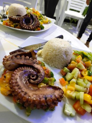 two plates of food with meat and rice on a table at Athiriveli in Thoddoo