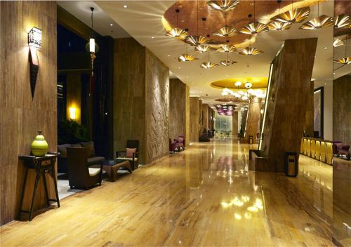 a lobby of a hotel with a hard wood floor and chairs at Mangrove Tree Resort World Sanya Bay-Kapok in Sanya