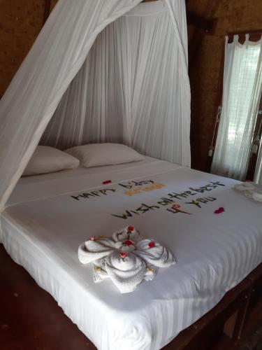 a white bed with two towels on top of it at Island View Bar & Bungalow in Gili Air
