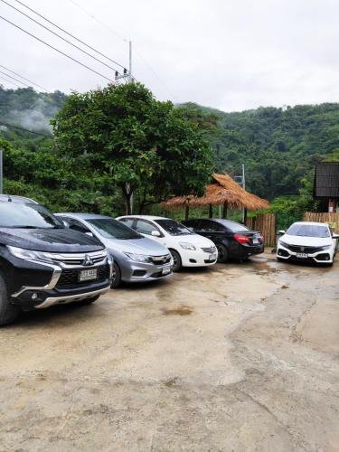 a row of cars parked in a parking lot at ม่านฟ้า โฮมสเตย์ MaanFah Homestay in Chiang Rai