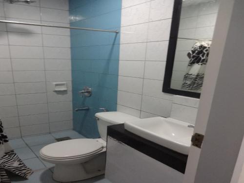 a bathroom with a toilet and a sink at Heilee's Guest House in General Santos