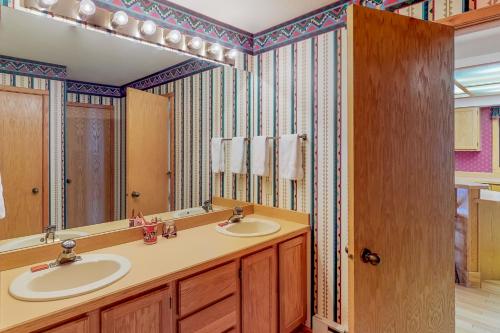 a bathroom with two sinks and a large mirror at Park 282 in Big Sky