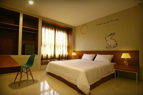 a bedroom with a bed and a desk and a television at CHERN Bangkok in Bangkok