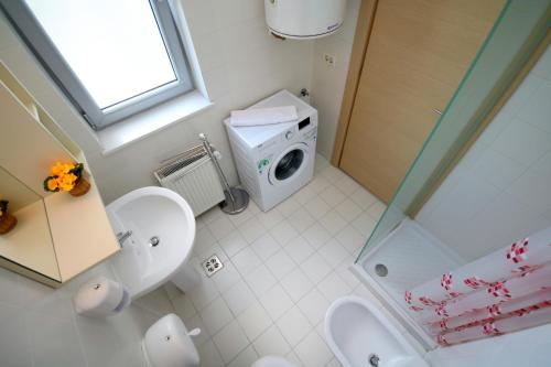 a bathroom with a shower and a washing machine at CoZy Apartments in Timişoara