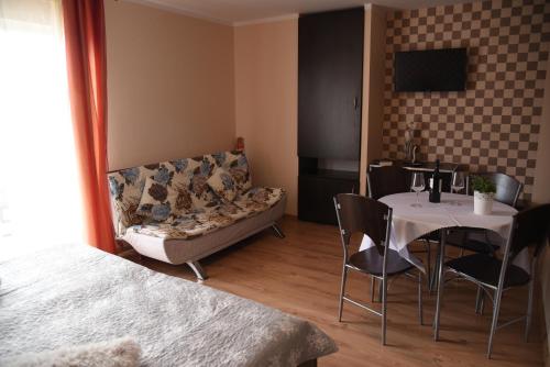 un soggiorno con un divano e un tavolo con sedie di Nestor II a Mrzeżyno