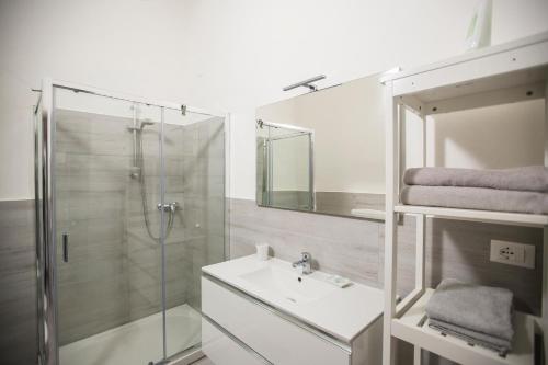 a bathroom with a glass shower and a sink at 700enolocanda in Santa Giuletta