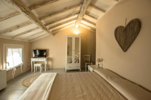 a bedroom with a bed with a heart on the wall at 700enolocanda in Santa Giuletta