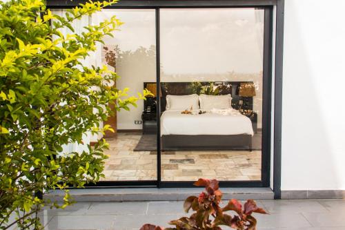 a bedroom with a bed and a large window at The Streamliner Hotel Apartment in Toamasina