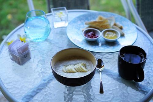 einen Tisch mit einer Schüssel Suppe und einem Teller Essen in der Unterkunft Mangga Bungalow in Sanur