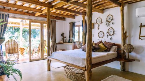 a bedroom with a bed in a room with windows at Sampaguita Villas in El Nido