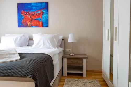 een slaapkamer met een bed en een schilderij aan de muur bij STUDIO 3 in Varna