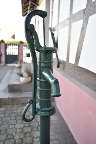 a green metal pole with a handle on a sidewalk at Appartement T3 Aux Deux Cigognes Gries in Gries