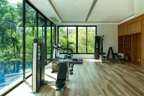 a gym with treadmills and machines in a room with windows at Avani Ao Nang Cliff Krabi Resort in Ao Nang Beach