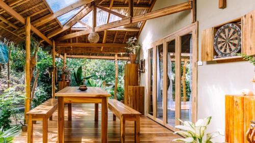 a room with a table and benches on a patio at Sampaguita Villas in El Nido