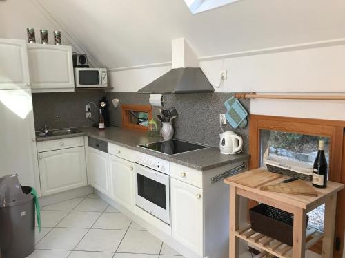 a kitchen with white cabinets and a sink and a stove at Chateau de Barbet 124 in Lombez