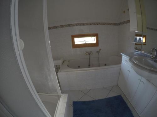 y baño con bañera y lavamanos. en Chateau de Barbet 124, en Lombez