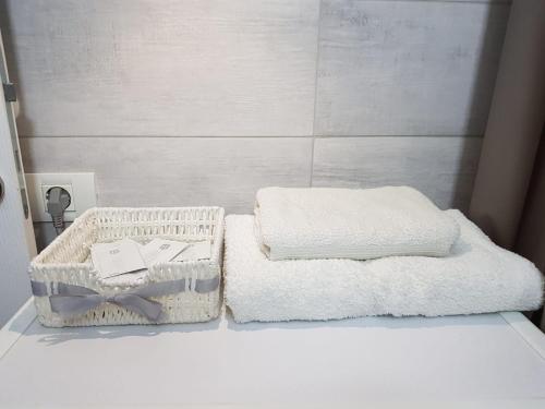 two towels in a basket on a counter in a bathroom at D&C Studio in Bucharest
