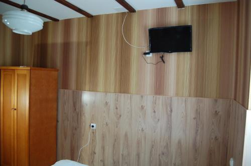 a bedroom with a tv on a wooden wall at Stivan Iskar Hotel in Sofia
