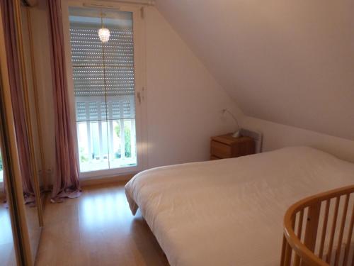 een slaapkamer met een bed en een groot raam bij Chez Grace in Wissant