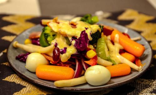 a plate of food with vegetables on a table at Li River Resort Villa Hotel in Guilin