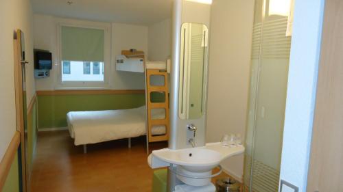a small bathroom with a sink and a bed at Ibis budget Wien Messe in Vienna