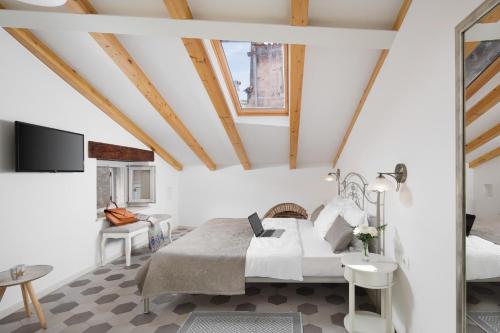een slaapkamer met een bed en een tv in een kamer bij Noemi's rooms in Rovinj