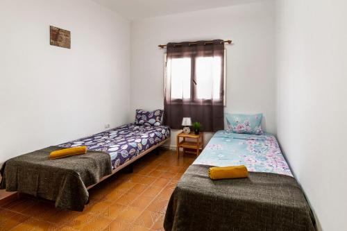 a room with two beds and a window at Vacation Apartment Lanzarote VAL in Puerto del Carmen