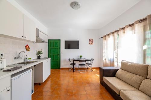 a kitchen and living room with a couch and a table at Vacation Apartment Lanzarote VAL in Puerto del Carmen