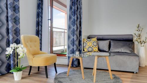 a living room with a couch and a chair at Dom & House - Apartments Waterlane Island in Gdańsk