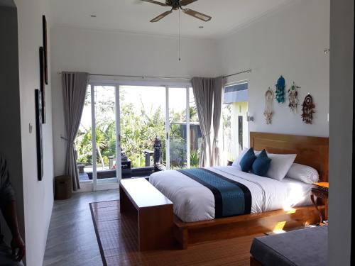 um quarto com uma cama e uma grande janela em Wanagiri Cosmic Nature Villa em Bedugul