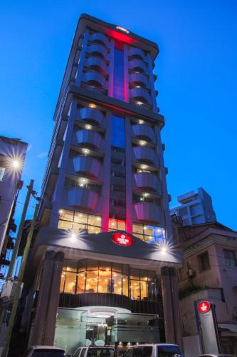 a tall building with red lights on top of it at Sleep Inn Hotel - City Centre in Dar es Salaam