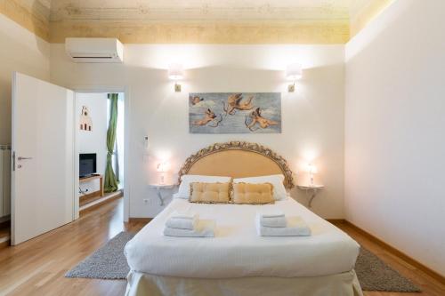 una camera con un grande letto bianco di Roommo Ghiberti a Firenze