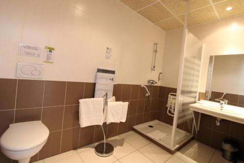 a bathroom with a toilet and a sink at The Originals Boutique, Hôtel du Pont Roupt, Mende in Mende