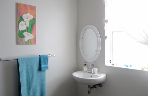 a white bathroom with a sink and a mirror at 21 ON BAKOOND in Yzerfontein