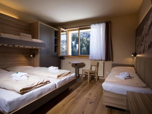 a hotel room with two beds and a table at JUFA Hotel Malbun in Malbun