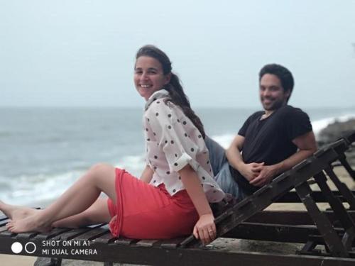 a man and a woman sitting on a bench at the beach at Cherai Ocean View Home in Cherai Beach