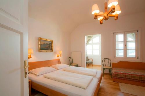 a bedroom with a bed and a chandelier at Hotel Seehof in Maria Wörth