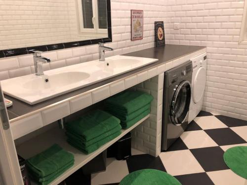 a bathroom with a sink and a washing machine at 2 Rue de l'Église in Aizecourt-le-Haut