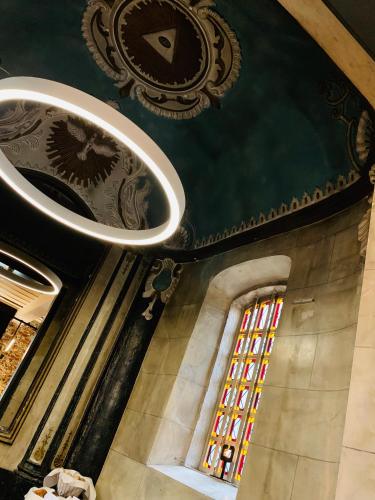 a ceiling with a clock and a window in a building at Landgoed Kasteel de Hoogenweerth in Maastricht