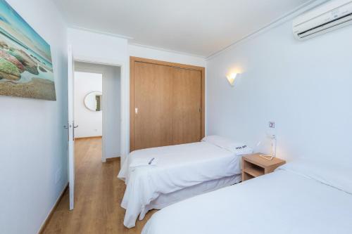 En eller flere senge i et værelse på Apartamentos Iris