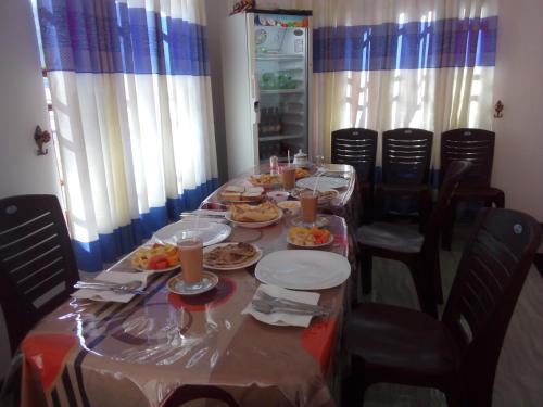 a long table with plates of food on it at Lavendra Guset House in Adams Peak