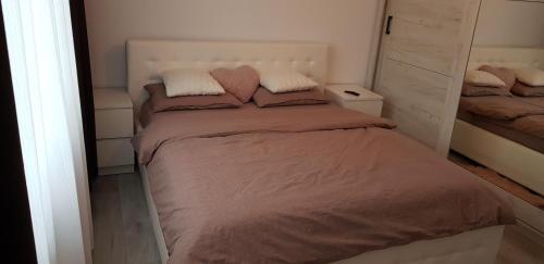 a bedroom with a large bed with two pillows at Apartament Rosenau in Râşnov