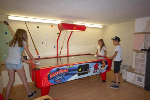 a group of children playing with a ping pong table at Kinderhotel Stefan in Wenns