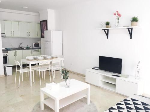 sala de estar blanca con mesa y cocina en Sagasta Beach Apartment IV by Canary365, en Las Palmas de Gran Canaria