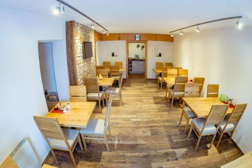 a dining room with wooden tables and chairs at Europa Pension Tirol in Fliess
