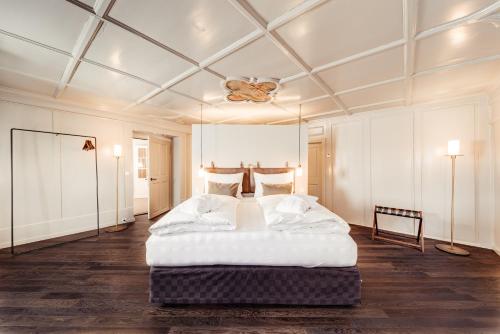 a bedroom with a large bed and a ceiling at Boutique Hotel das TSCHOFEN in Bludenz