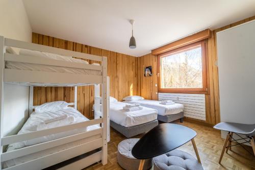 夏慕尼白朗峰的住宿－Grand appt vue Mont Blanc，客房设有两张双层床和一张桌子。