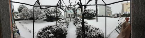 a window view of a garden covered in snow at B&B villa sempreverde in Locarno