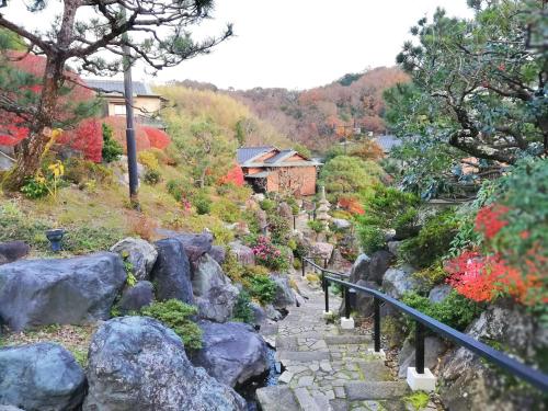 a stone path in a garden with rocks at Ishinoya Izunagaoka - TKP Hotels & Resorts in Izunokuni