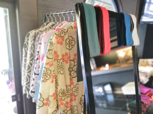 a rack of clothes are hanging on a shelf at Ishinoya Izunagaoka - TKP Hotels & Resorts in Izunokuni